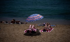 People sunbathe on a beach in Barcelona, Spain, Monday, July 17, 2023. Spain's Aemet weather agency said a heatwave starting Monday "will affect a large part of the countries bordering the Mediterranean" with temperatures in some southern areas of Spain exceeding 42-44 ºC. (AP Photo/Emilio Morenatti)