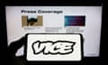  Person holding smartphone with logo of broadcasting company Vice Media LLC on screen in front of website. 