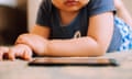 A close-up view of a male toddler watching videos from a smartphone on the floor in the living room