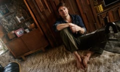 Josh Hartnett sitting barefoot on a fur rug