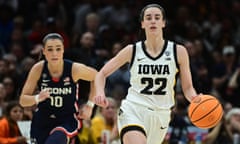 Iowa Hawkeyes guard Caitlin Clark (22) dribbles the ball past Connecticut Huskies guard Nika Muhl (10) during Friday’s national semi-final.