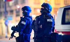 Armed police officers stand next to a vehicle in Vienna