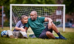 Mason Twala with his arms around Siyabonga as the pair sit in front of a football goal