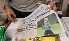 A customer buys a copy of the Daily Telegraph