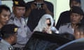 Schapelle Corby covers her head with a scarf as she is escorted by Indonesian police officers outside a parole office in Bali.