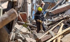 A rescue worker searches for suvivors in the rubble of earthquake-damaged houses