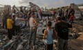 A group of people standing amid the rubble of destroyed buildings