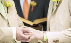 Man placing ring on another man's finger