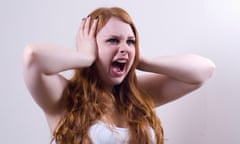 Young woman clutches head in anger