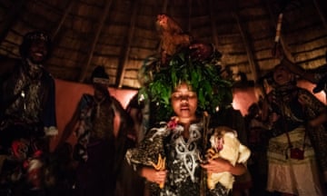 A sangoma trainee holds chickens and meditates during her initiation ceremony.
