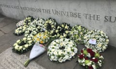 Mostly white flowers on the floor by a plaque