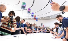 Launch event for the iPhone 14 with new phones on a strand surrounded by journalists and others