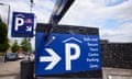 a big white arrow underneath a big blue car parking sign