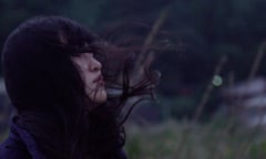 a still from All of Our Heartbeats Are Connected Through Exploding Stars showing a young man and a young woman looking into a tank of water