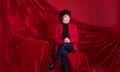 Ruby Wax seated in front of a red velvet backdrop