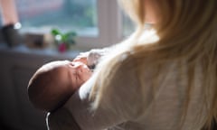 Unrecognisable young mother holding baby son in her arms