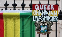 A placard of the  Ghanaian flag above its coat of arms saying "queer Ghanaian lives matter" attached to railings outside a building