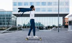 A young businessman riding skateboard in the city of Barcelona, Spain.