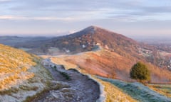 A heavily worn footpath on Perseverance Hill, Malvern Hills, is cast in shadow from the strong light of sunrise.<br>DWH7N4 A heavily worn footpath on Perseverance Hill, Malvern Hills, is cast in shadow from the strong light of sunrise.