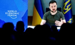 Volodymyr Zelenskiy is seen on a screen as he delivers a video address to the delegates of the World Economic Forum in Davos.