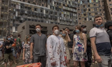 People stand amid the rubble of Okhmatdyt children’s hospital after a Russian missile attack in Kyiv.