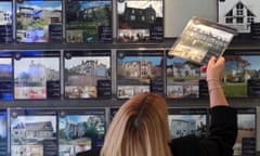 Back of woman's head changing estate agent window display