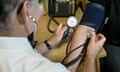 A doctor measures a patient's blood pressure.