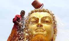 a monk cleaning a statue of buddha in bhopal