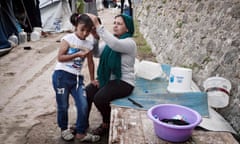 TOPSHOT - A Syrian Kurd mother combs Roza's hair, as she prepares to go to a volunteer-run school in a refugee camp on the island of Chios on October 13, 2016. 
Some 270 refugee children are learning English, mathematics, arts and creative skills with "Be Aware and Share" (BAAS), a Swiss NGO which has been active on Chios since May. Operating out of a converted former restaurant in the island's port capital, the 20-strong team runs classes for children from the age of six, as well as workshops for teenagers about cooking or going to the supermarket. The school also promotes acceptance of other national backgrounds. And hygiene, including toothbrush use.
 / AFP PHOTO / LOUISA GOULIAMAKILOUISA GOULIAMAKI/AFP/Getty Images