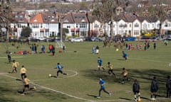 Photo by Richard Baker. With the wider city in the distance, youth teams play a football match in a south London park.