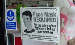 A face mask sign in a shop window.