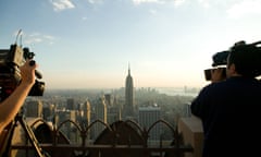 A TV crew shoots footage of Midtown Manhattan and the Empire State Building from the Top Rock viewing area atop the Rockefeller Television cameraman camera