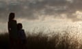 Women and child silhouette looking out over grey skyline