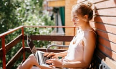 Young woman working on laptop in balcony