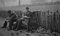 Two men feeding birds in a park