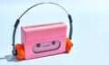 Front view of pink portable audio cassette player, cassette tape and vintage headphones on blue background