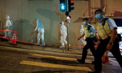 Workers in protective suits arrive at the locked-down part of the Sai Ying Pun area to contain a new outbreak of coronavirus in Hong Kong on Monday.