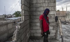 A gang member, wearing a balaclava and holding a gun, poses for a photo in the Portail Leogane neighbourhood of Port-au-Prince, Haiti.