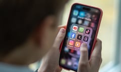 A schoolboy looks at an iPhone screen