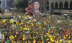 Demonstrators demanding the impeachment of Brazil's President Dilma Rousseff march during a protest next to large inflatable dolls of former President Luiz Inacio Lula da Silva and President Rousseff