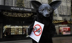 A campaigner dressed as a fox holds a banner during an anti-fur protest outside House of Fraser in London in December 2019. 