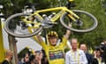 Jonas Vingegaard celebrates his 2023 Tour de France victory by lifting his bike in Paris