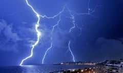 Bolts of lightning strike the ocean off the coastal city Montevideo at night