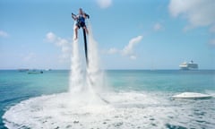 PAOLO WOODS & GABRIELE GALIMBERTI's series 
THE HEAVENS, ANNUAL REPORT on shoe at Arles Photo Festival 2015
An employee of "Jetpack Cayman" demonstrates this new watersport, now available on the island. A 2000cc motor pumps water up through the Jetpack, propelling the client out of the sea (359 USD for a 30-minute session). Mike Thalasinos, the owner of the company, remarks,    The Jetpack is zero gravity, the Cayman are zero taxes, we are in the right place! Grand Cayman.