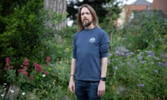 Andy Evans posing against garden flowers