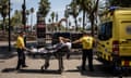 Paramedics wheel a patient on a stretcher towards an ambulance during a heatwave in Spain.