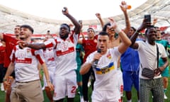 Stuttgart's players celebrate with fans on the pitch after securing Bundesliga survival