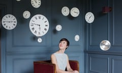 Woman in armchair with hanging clocks above<br>GettyImages-185921370