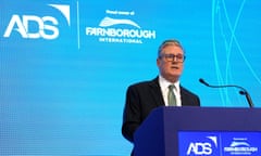 Keir Starmer behind a lectern in front of a blue background with the Farnborough airshow logo