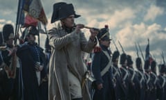 Joaquin Phoenix as Napoleon on the battlefield with an eyeglass and a row of soliders behind him